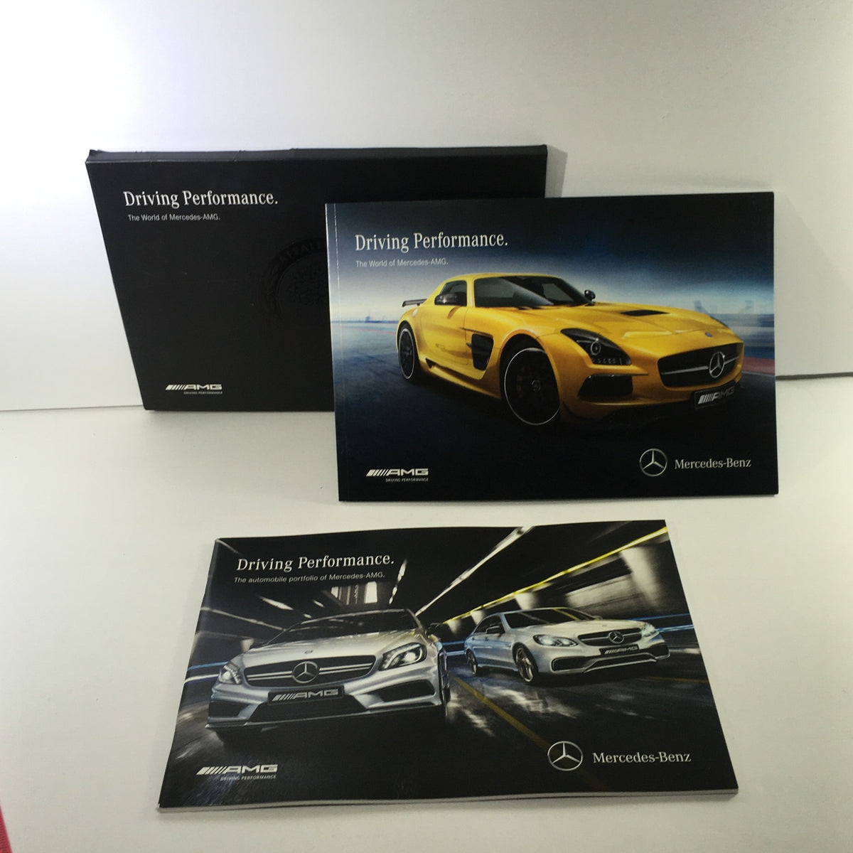 2013 Mercedes-Benz AMG Portfolio Dealership Car Auto Brochure Catalog showcasing a sleek yellow sports car and dynamic Mercedes-Benz models. Perfect for collectors and enthusiasts.