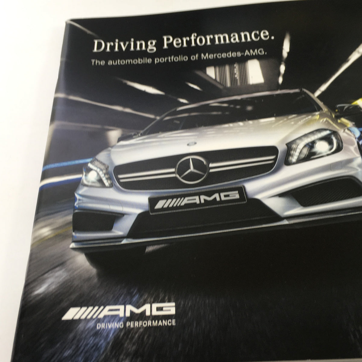 Cover of the 2013 Mercedes-Benz AMG Portfolio Dealership Car Auto Brochure Catalog featuring a sleek silver Mercedes-AMG vehicle and the text 'Driving Performance.'