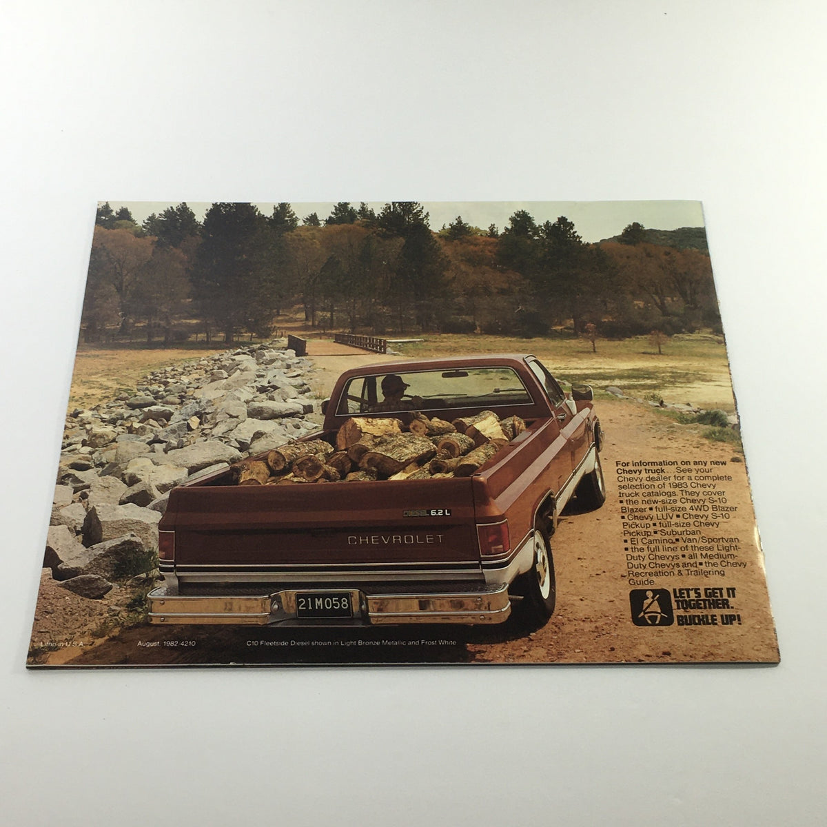 Back cover of the 1983 Chevrolet Full-Size Pickup Dealership Car Auto Brochure Catalog showing a truck carrying logs at a scenic location.