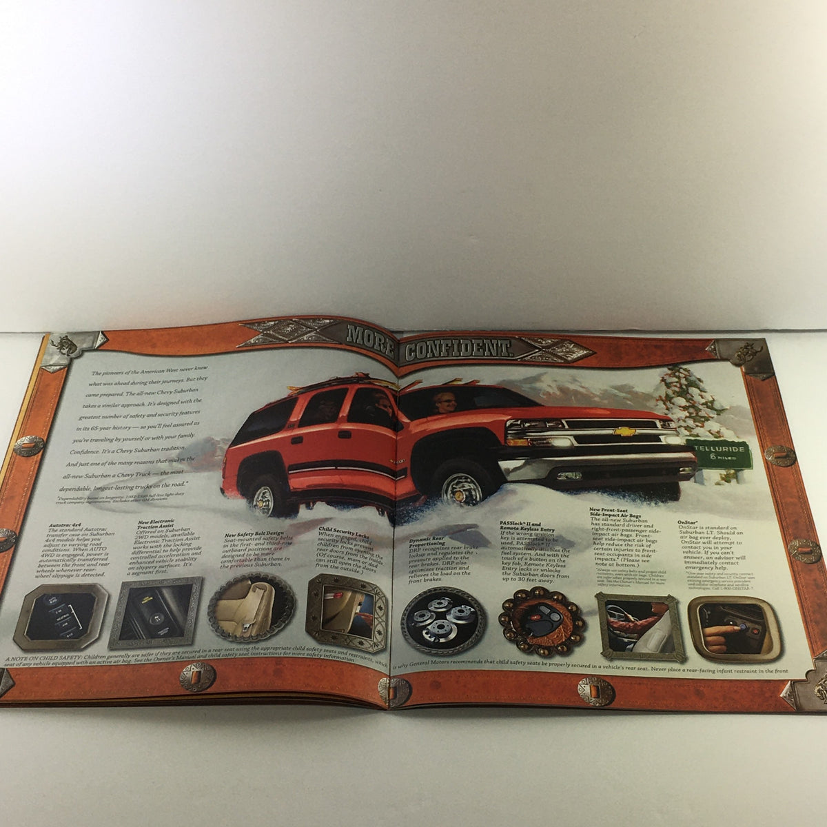 2000s Chevrolet Chevy Suburban Dealership Car Auto Brochure Catalog displaying a red Chevrolet Suburban in a winter scene, highlighting features of the vehicle.
