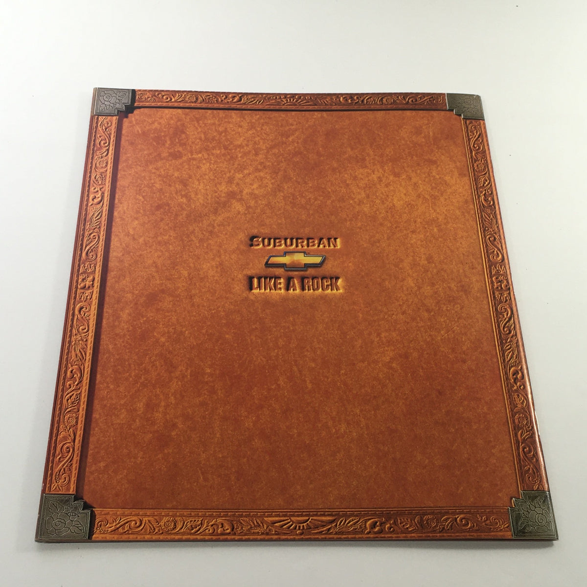 2000s Chevrolet Chevy Suburban Dealership Car Auto Brochure Catalog cover featuring an embossed design with 'Suburban Like a Rock' title.