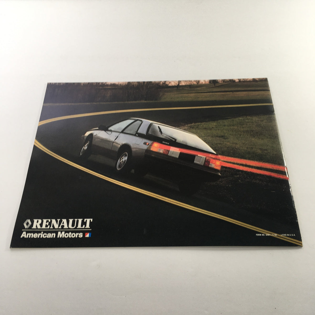 1984 Renault Fuego Turbo Coupe Dealership Car Brochure image of the Fuego model on a winding road, demonstrating performance.