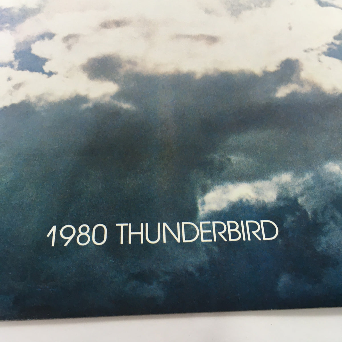 Close-up view of the '1980 THUNDERBIRD' text on the cover of the Ford Thunderbird Dealership Car Auto Brochure Catalog.