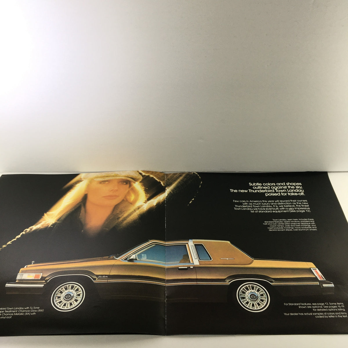 1980 Ford Thunderbird Dealership Car Auto Brochure Catalog featuring a gold Thunderbird model and a model in a fashionable outfit, showcasing the car's sleek design and luxury features.