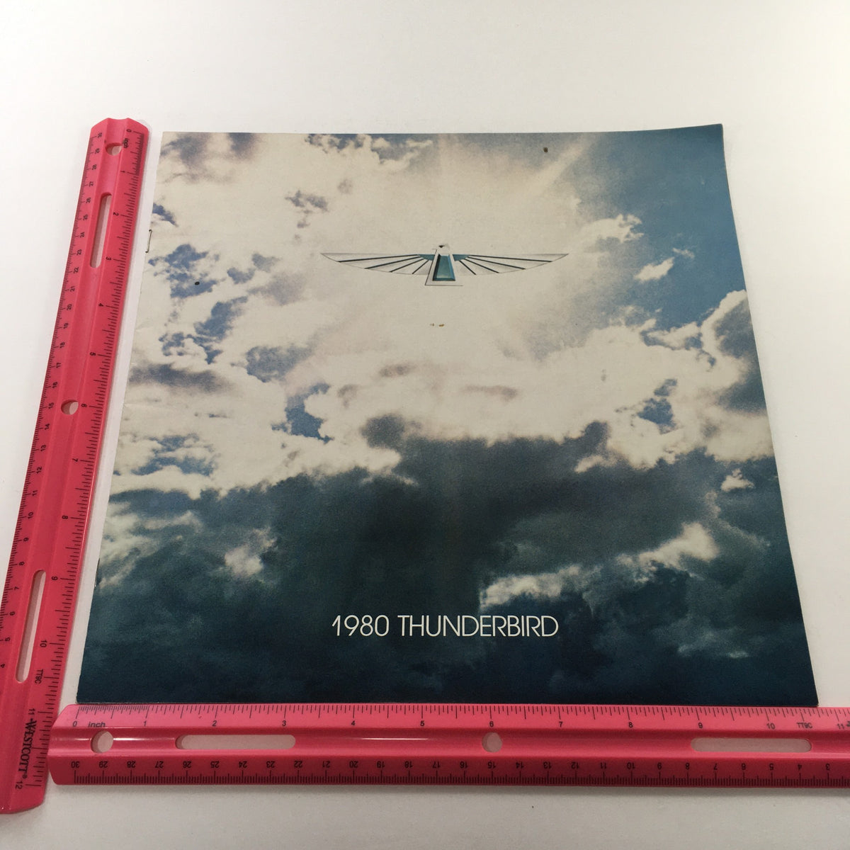 Front cover of the 1980 Ford Thunderbird Dealership Car Auto Brochure Catalog, displaying the iconic Thunderbird logo against a cloudy blue sky backdrop.