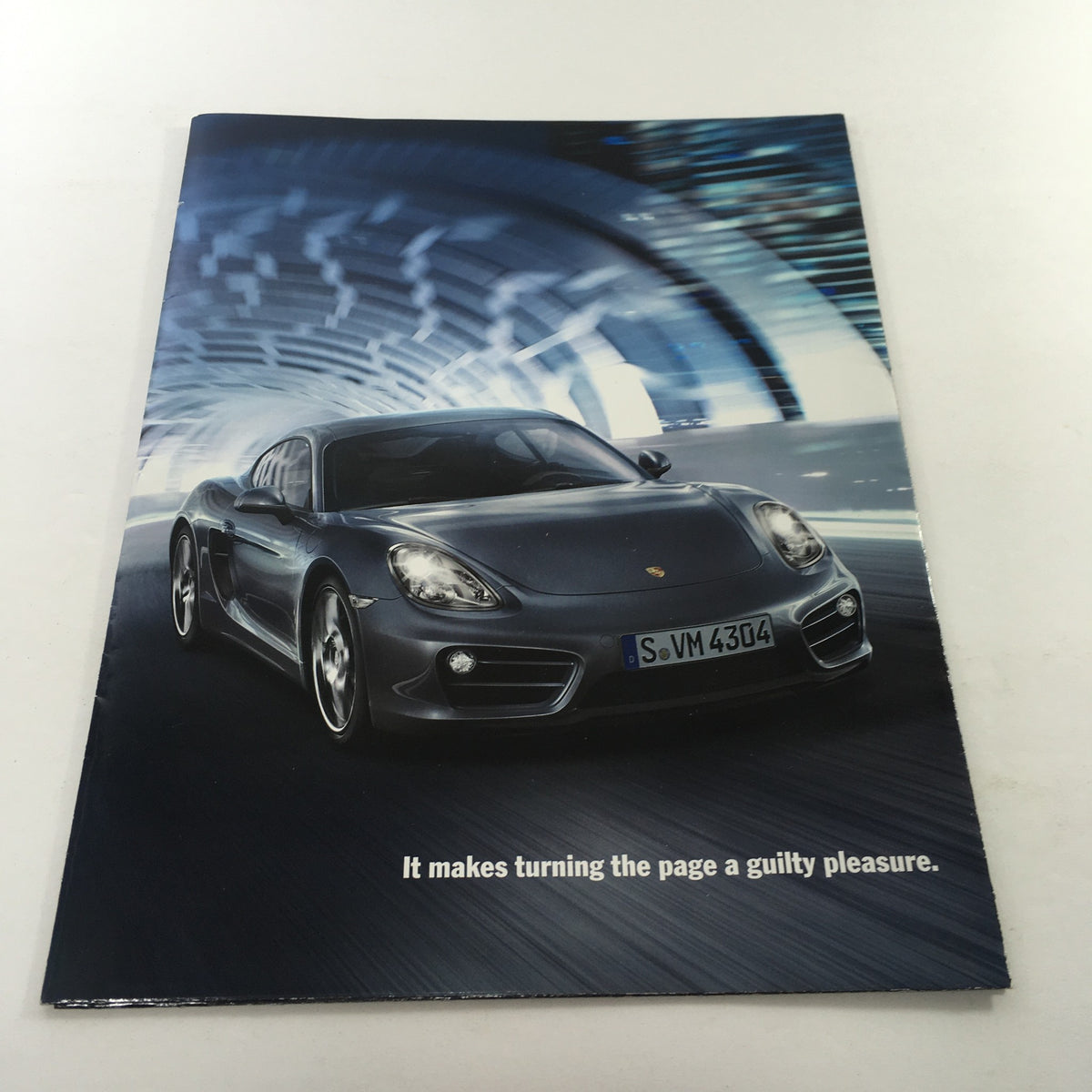 2013 Porsche Cayman Code Dealership Car Auto Brochure Catalog front cover featuring a sleek gray Porsche Cayman in an illuminated tunnel.