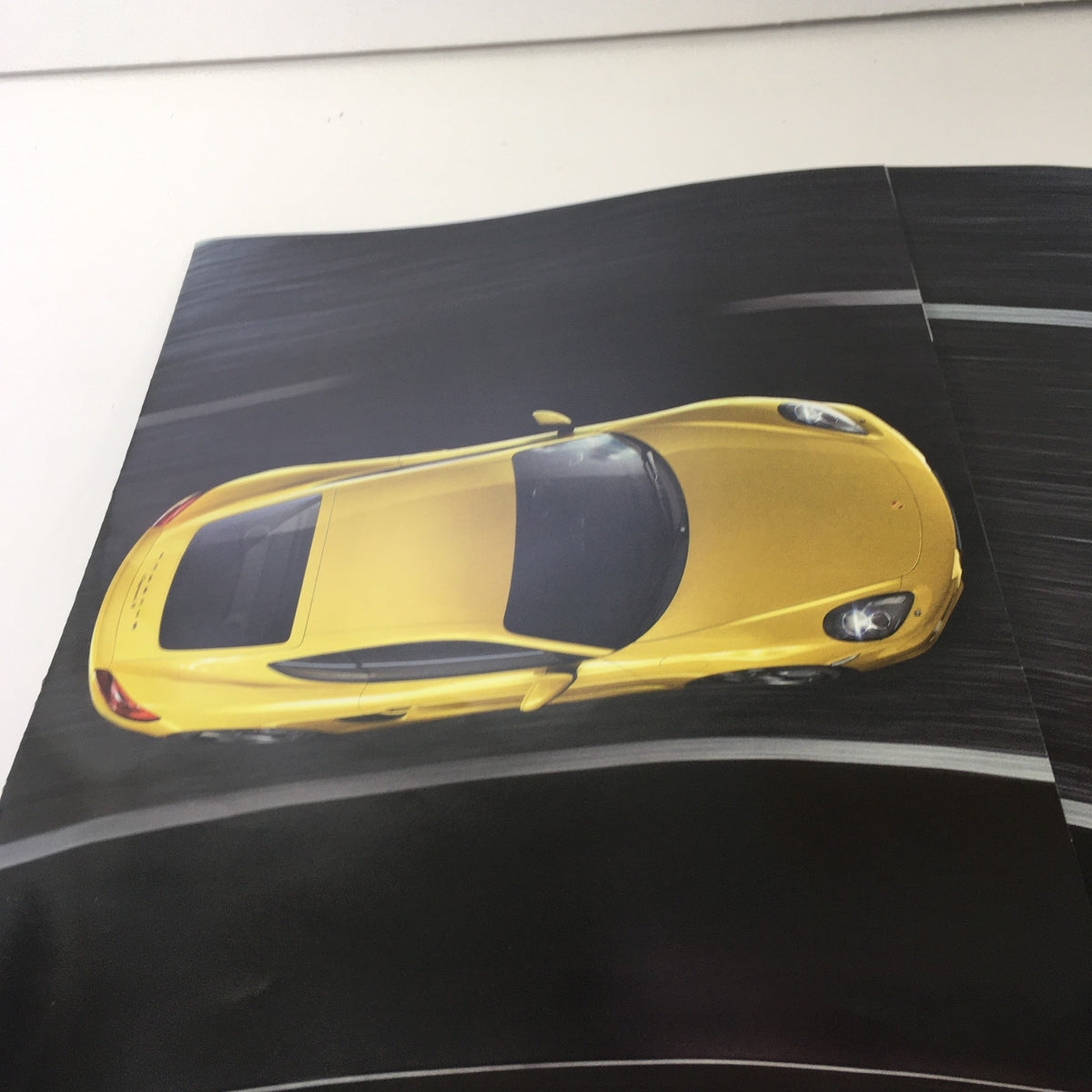 2013 Porsche Cayman Code Dealership Car Auto Brochure Catalog interior page showcasing a vibrant yellow Porsche Cayman from a top-down perspective.