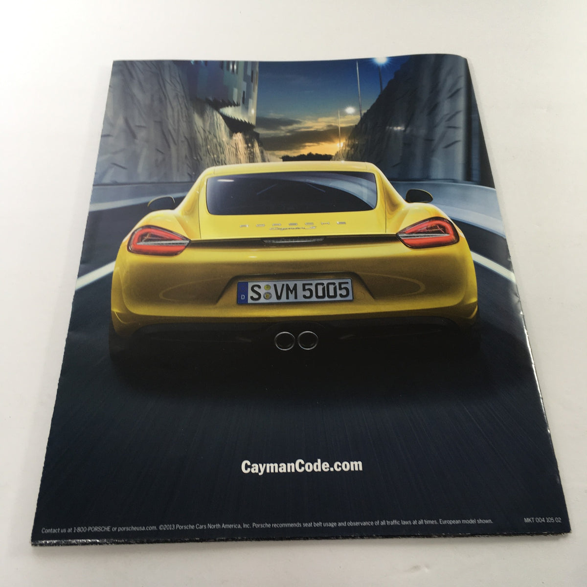 2013 Porsche Cayman Code Dealership Car Auto Brochure Catalog back cover featuring a bold yellow Porsche Cayman with 'CaymanCode.com' highlighted.