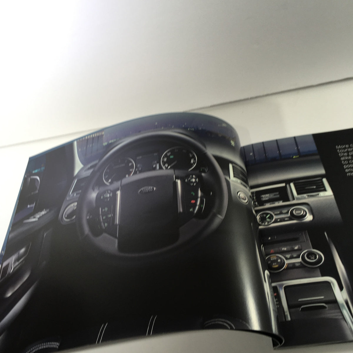 Interior view of the 2010 Land Rover Range Rover Sport Dealership Car Auto Brochure Catalog, showcasing the dashboard and steering wheel.