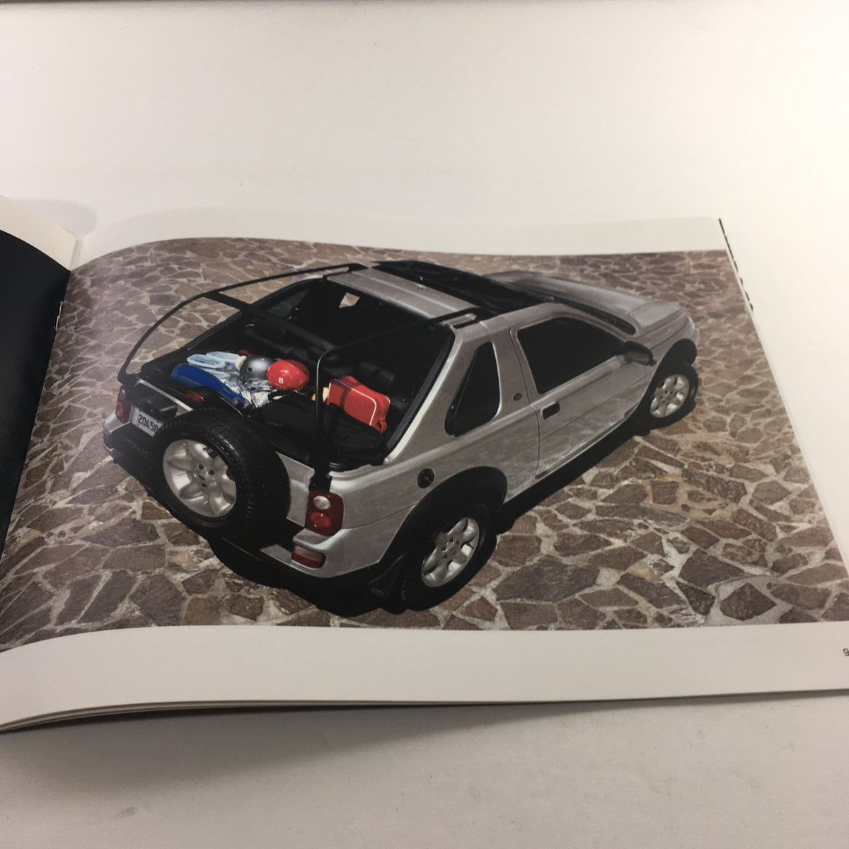Interior page of the 2004 Land Rover Product Guide displaying a silver Land Rover vehicle from an aerial perspective.