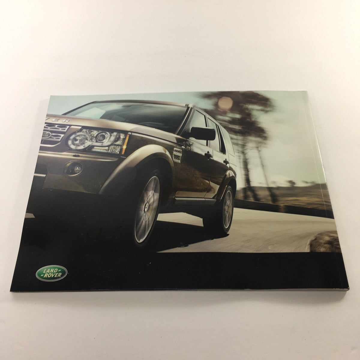 Side view of a 2010 Land Rover LR-4 captured in motion on a road, from the auto brochure catalog.