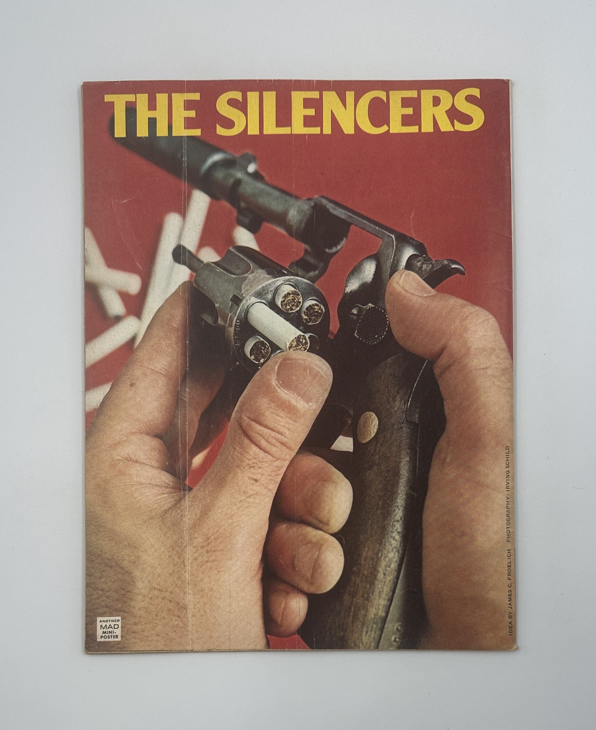 Back cover of MAD Magazine No. 174 from April 1975 showcasing an illustration of a hand holding a revolver, titled 'The Silencers'.
