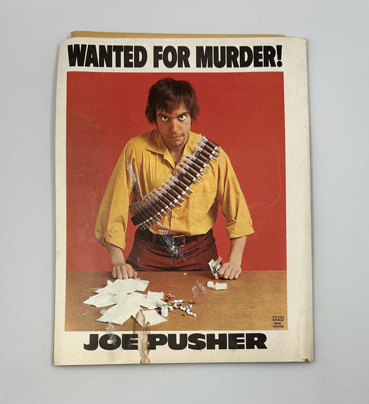 Back cover of MAD Magazine Super Special No. 19 featuring a dramatic illustration of a character named Joe Pusher, with a wanted poster theme, enhancing the magazine's satirical tone.