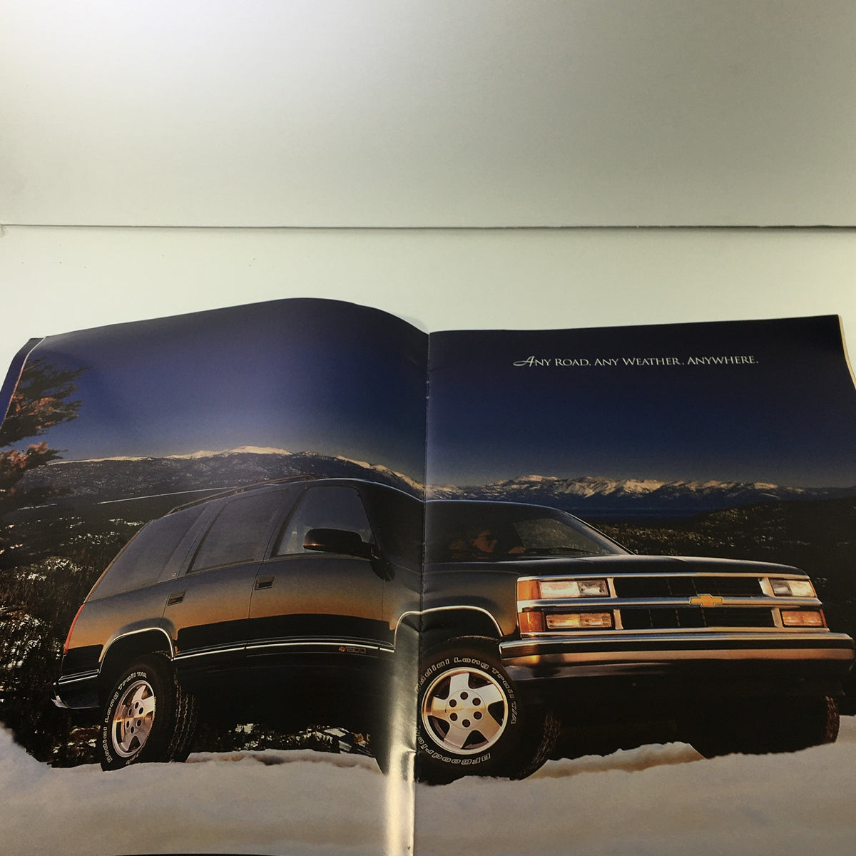 Another inside view of the 1995 Chevrolet Tahoe Dealership Car Auto Brochure displaying the SUV against a mountain backdrop with the phrase 'Any Road. Any Weather. Anywhere.'