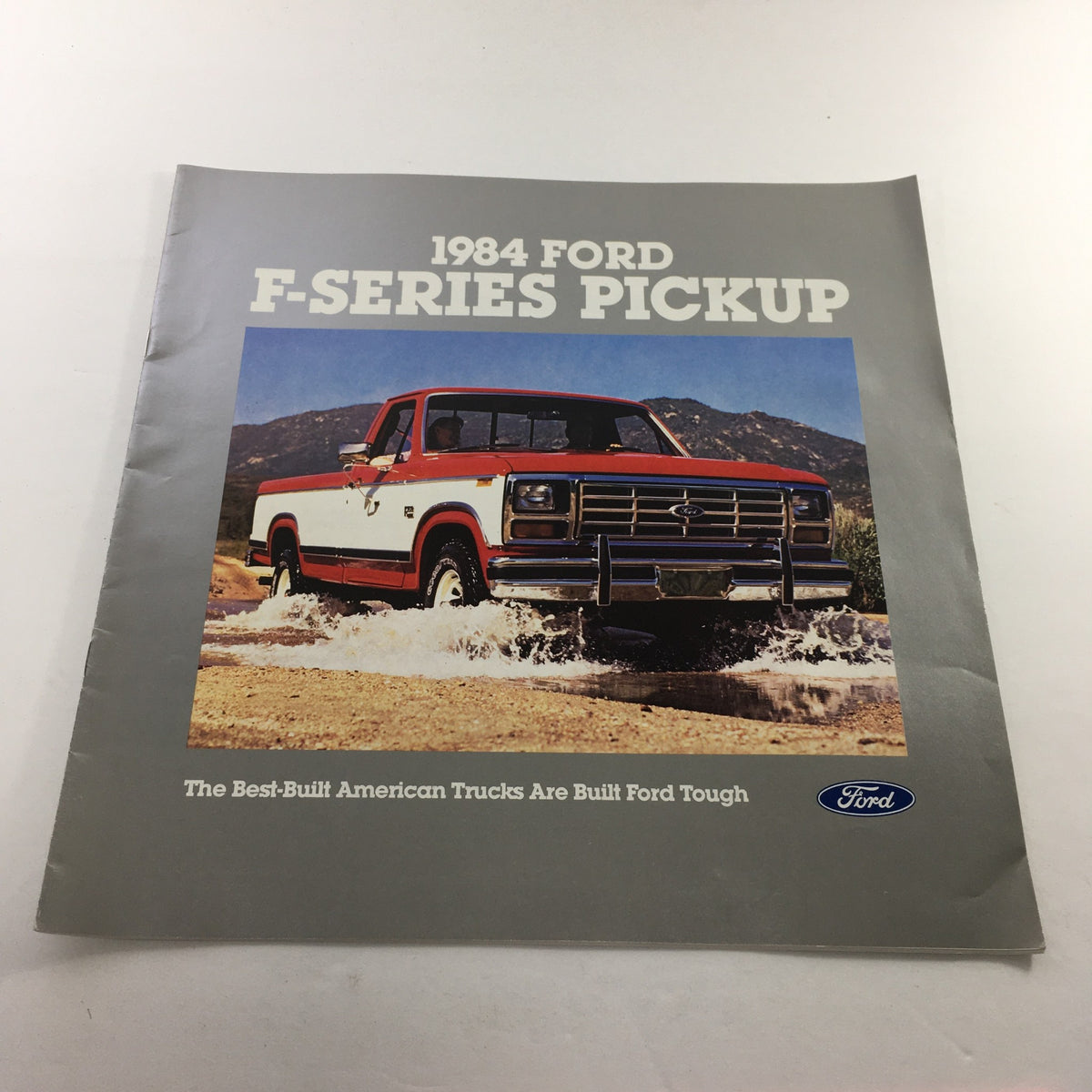 1984 Ford F-Series Pickup dealership brochure showcasing the truck on a rugged terrain with a scenic background. Highlights the durability and design of the best-built American trucks.