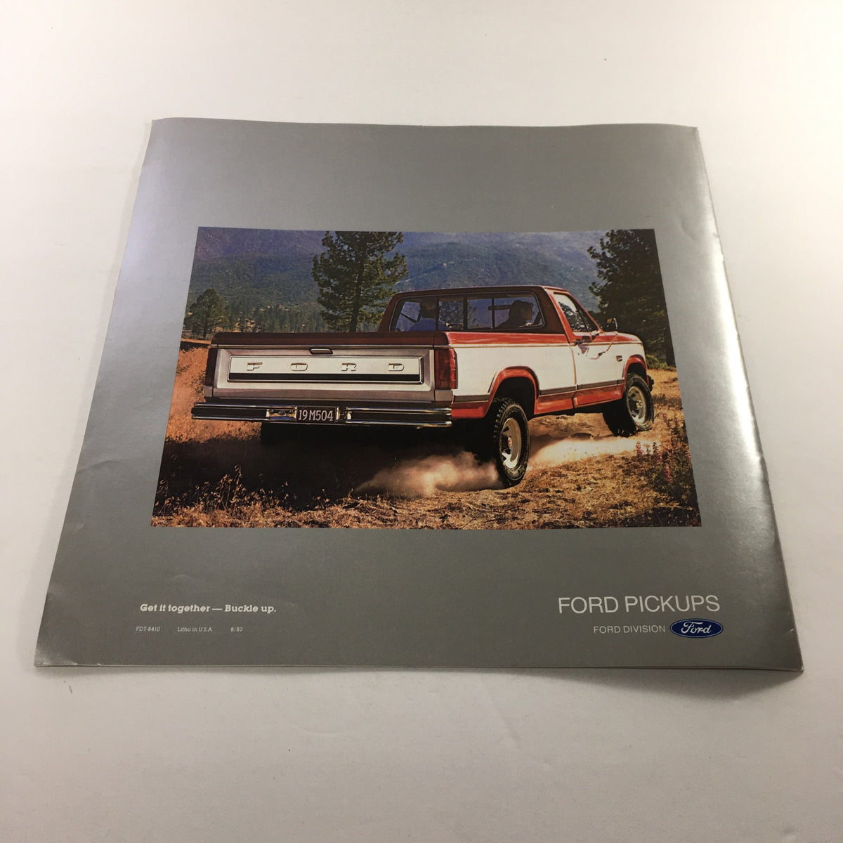 1984 Ford F-Series Pickup Dealership Car Auto Brochure Catalog featuring a red and white Ford pickup truck on a dirt road with a scenic background, showcasing Ford's rugged design.
