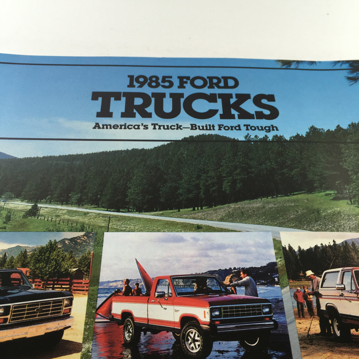 Close-up of the 1985 Ford Trucks Ranger brochure cover, highlighting the text '1985 FORD TRUCKS' and 'America's Truck—Built Ford Tough' against a scenic background.