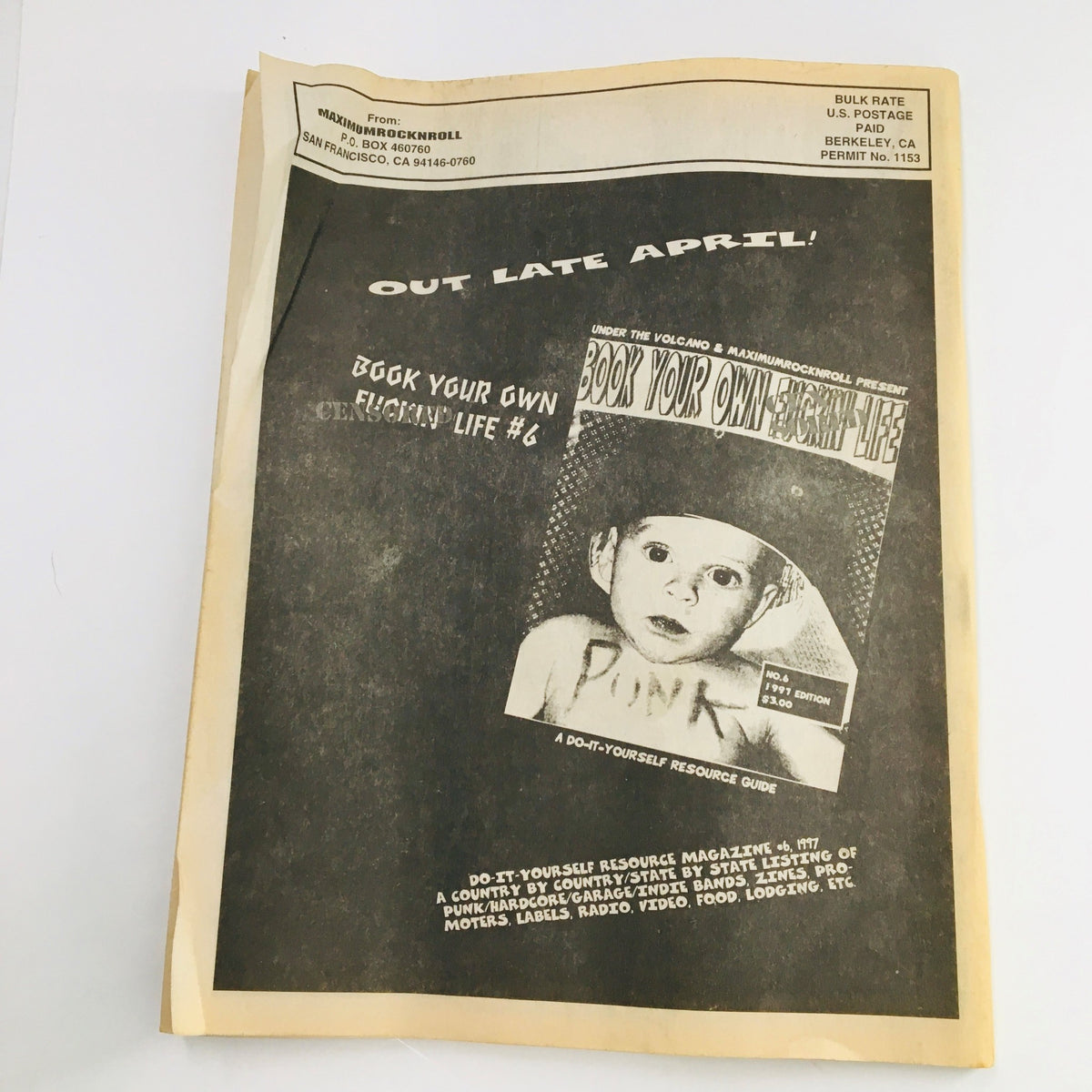 Cover of Maximum RocknRoll Magazine April 1997 featuring punk culture insights and a promotion for 'Book Your Own Fucking Life', showcasing the underground punk scene.