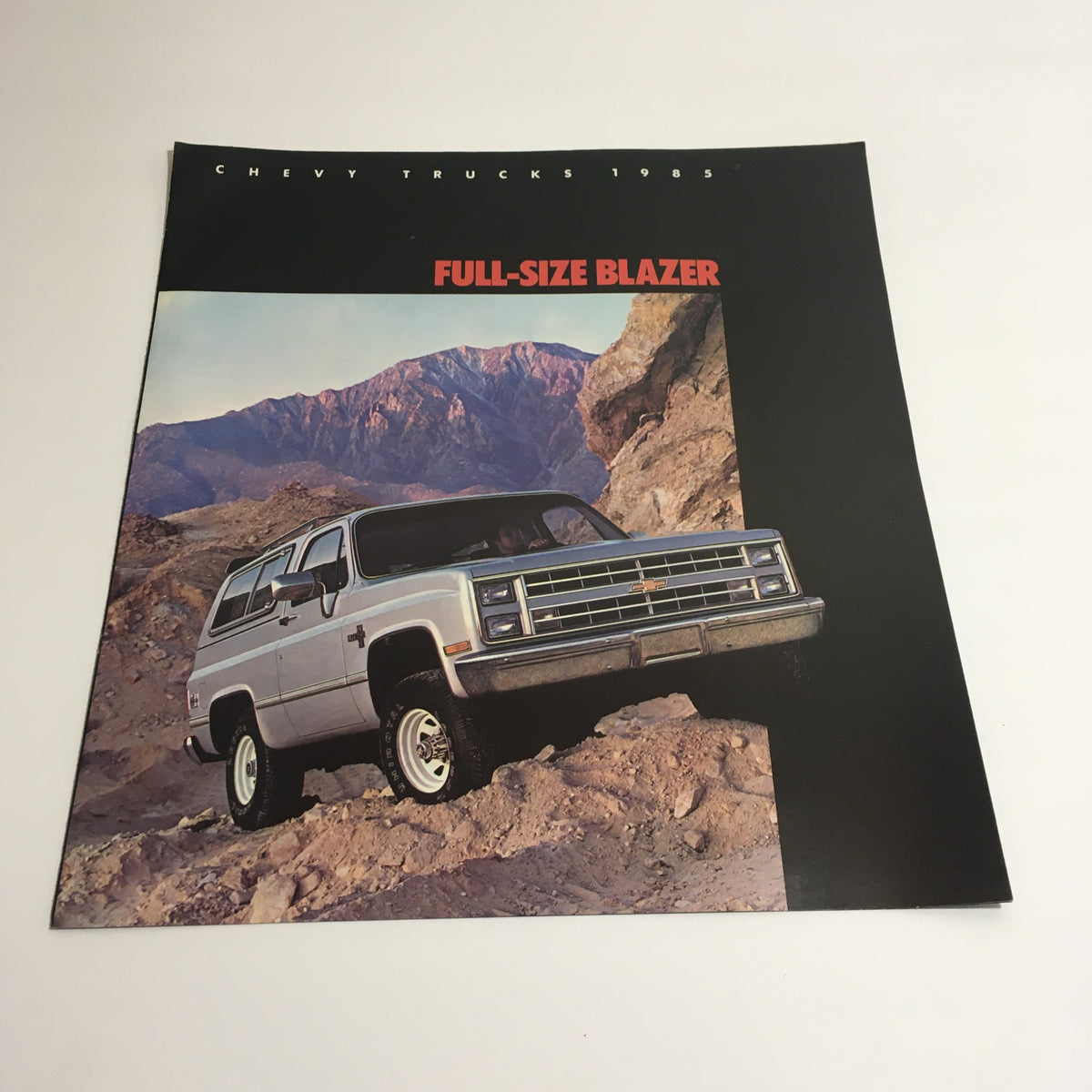 Close-up of the 1985 Chevy Trucks Full-Size Blazer dealership brochure featuring off-road illustration.