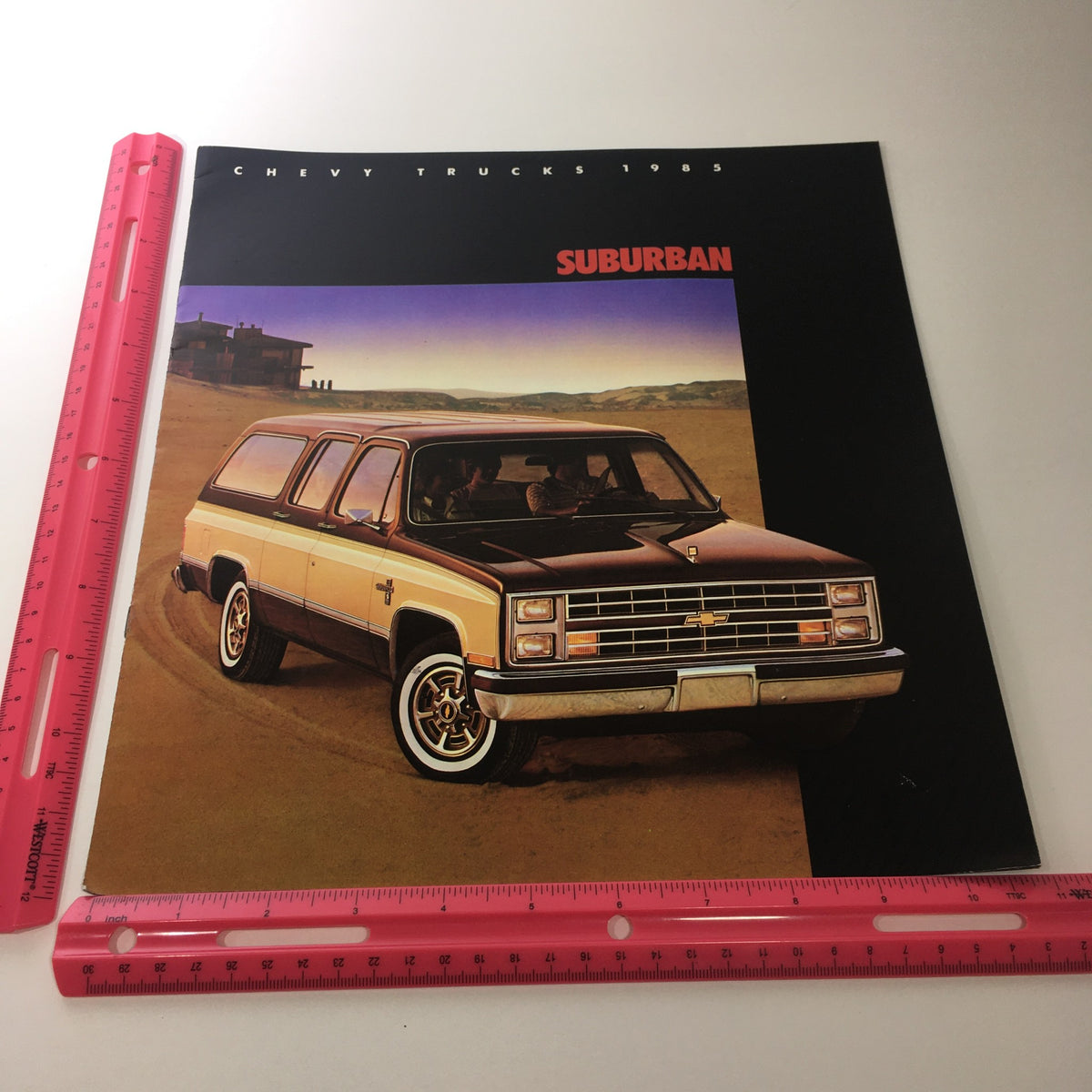 Measurement reference alongside the cover of the 1985 Chevy Trucks Full-Size Blazer Dealership Brochure Catalog illustrating the Chevy Suburban's design.