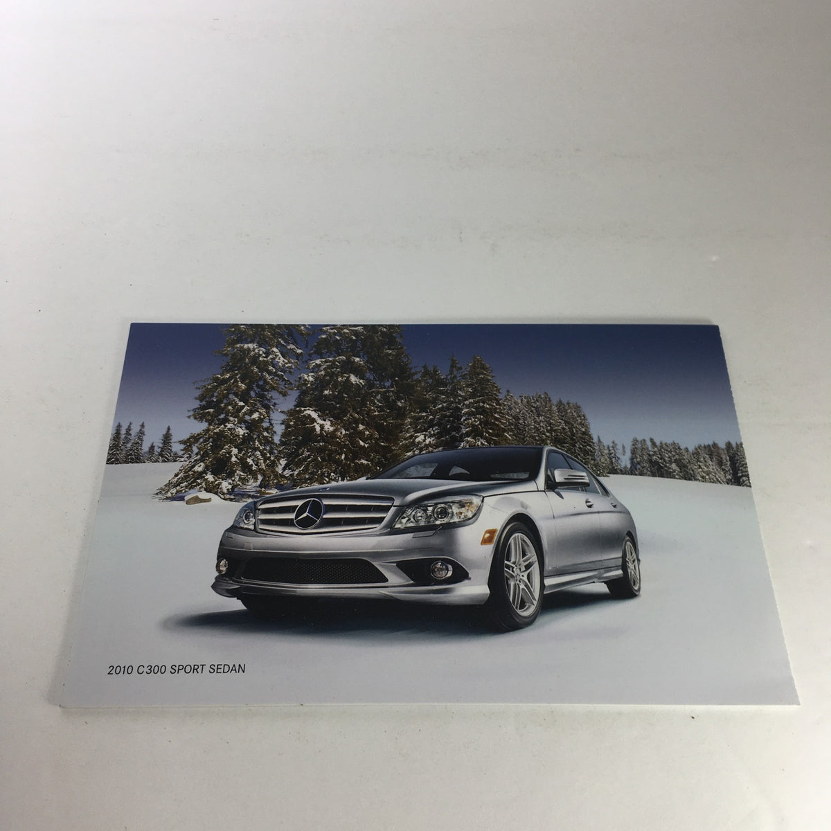 Promotional image of a 2010 Mercedes-Benz C300 Sport Sedan in a snowy landscape, showcasing its stylish design.