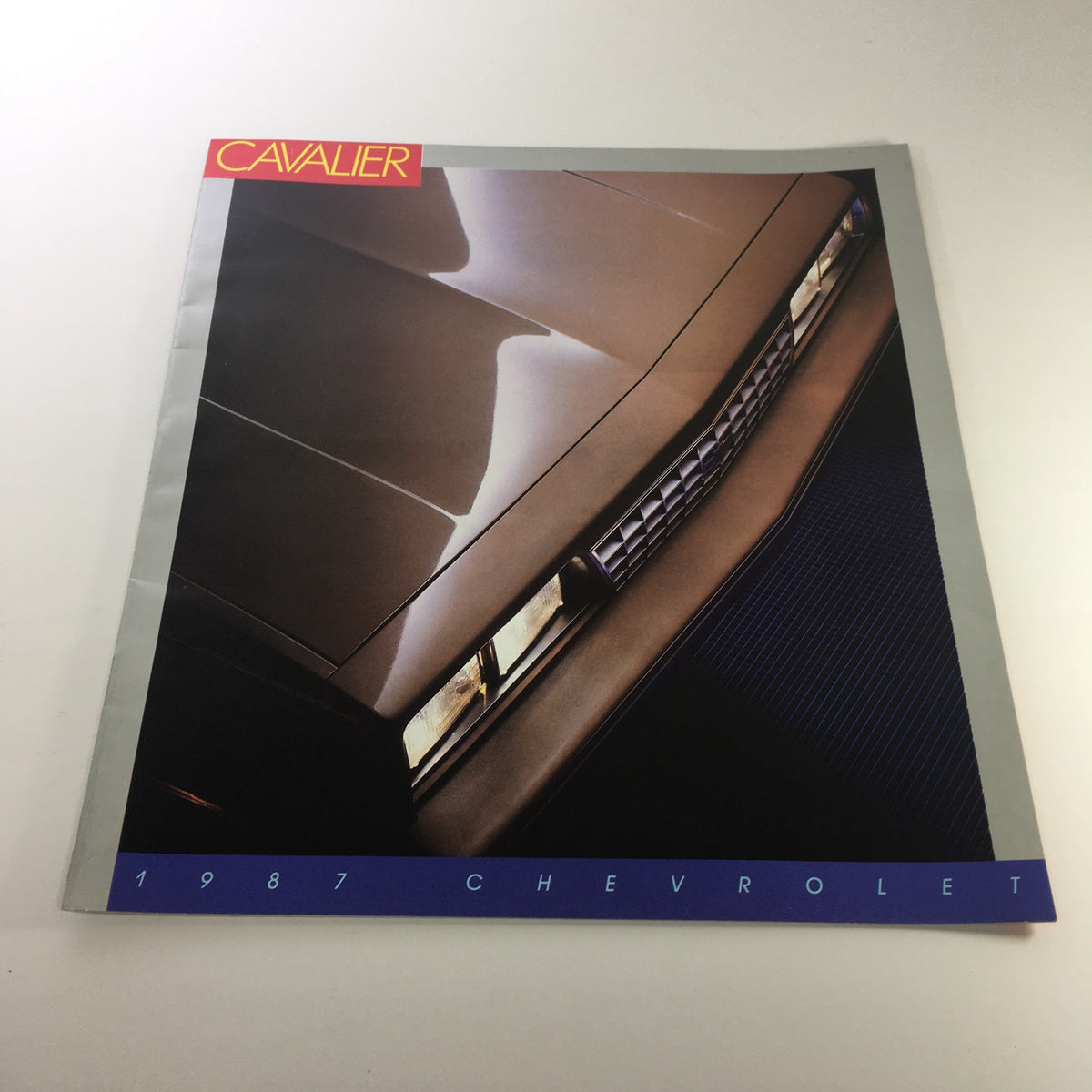 1987 Chevrolet Cavalier brochure showcasing the car's sleek front design, part of a lot of 8 dealership car brochure catalogs.
