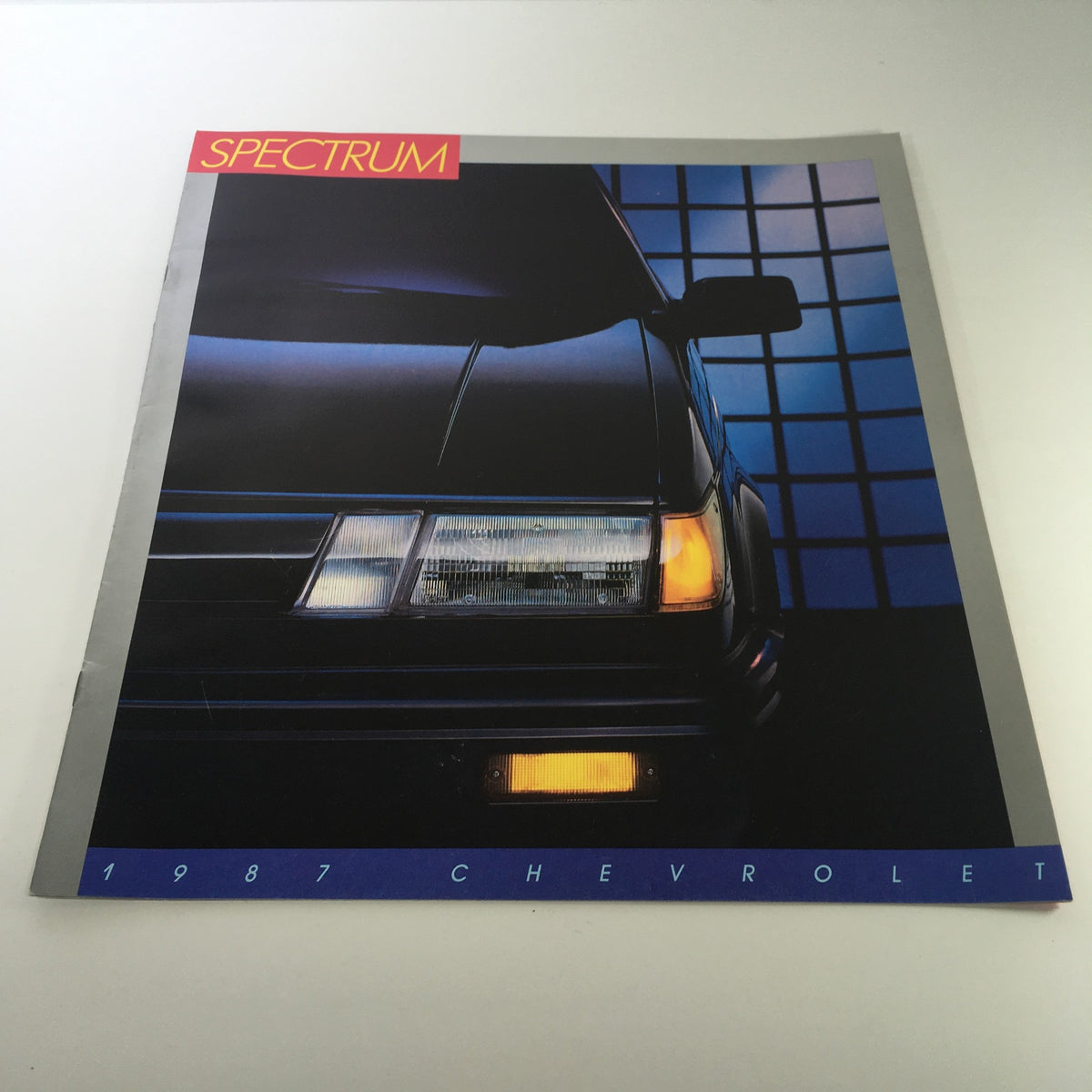 1987 Chevrolet Spectrum brochure highlighting the stylish front view of the car, part of a collection of 8 dealership car brochure catalogs.