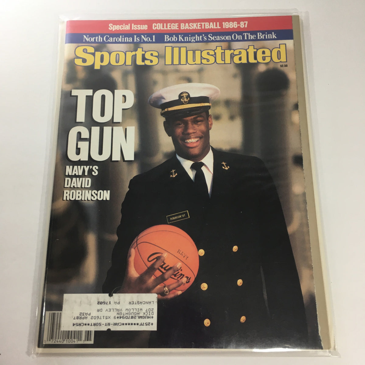 Cover of Sports Illustrated: College Basketball 1986-1987 featuring Top Gun Navy's David Robinson, showcasing him in Navy attire holding a basketball, highlighting his collegiate basketball achievements.