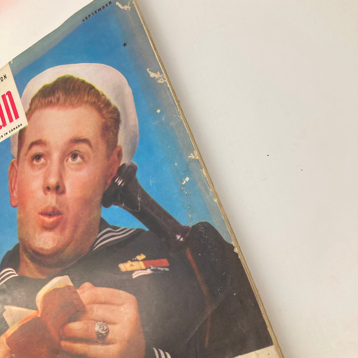 Detailed view of the cover of VTG The American Magazine September 1943, illustrating a sailor engrossed in reading, accompanying the article 'Losing Our Freedom'.