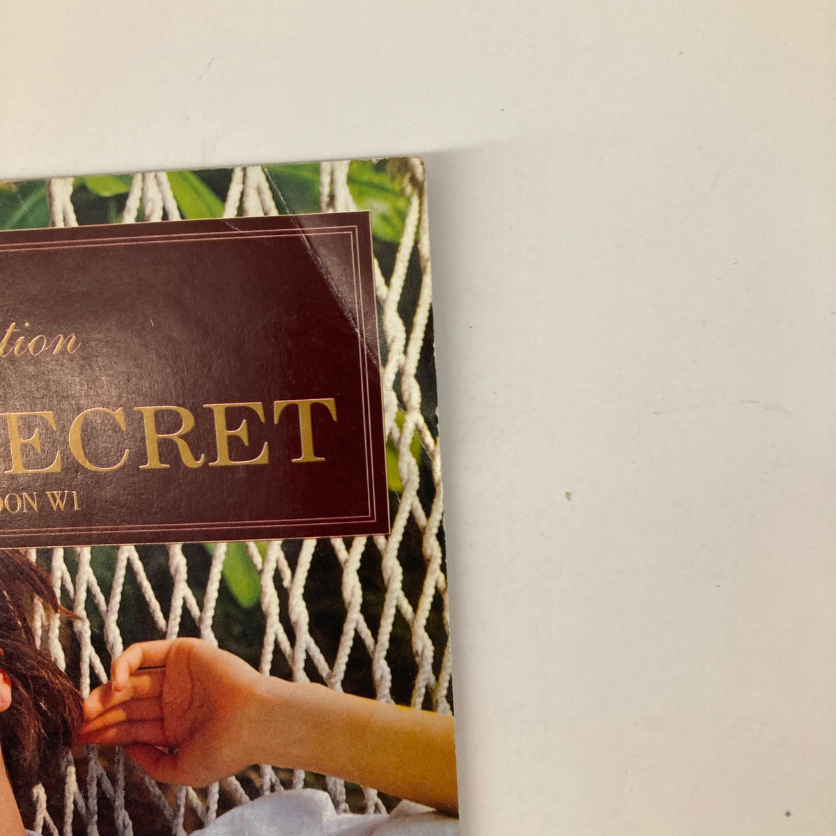 Close-up of Spring 1992 Collection Victoria's Secret No. 10 Catalog showing branding and model details in a hammock, highlighting the vintage design.