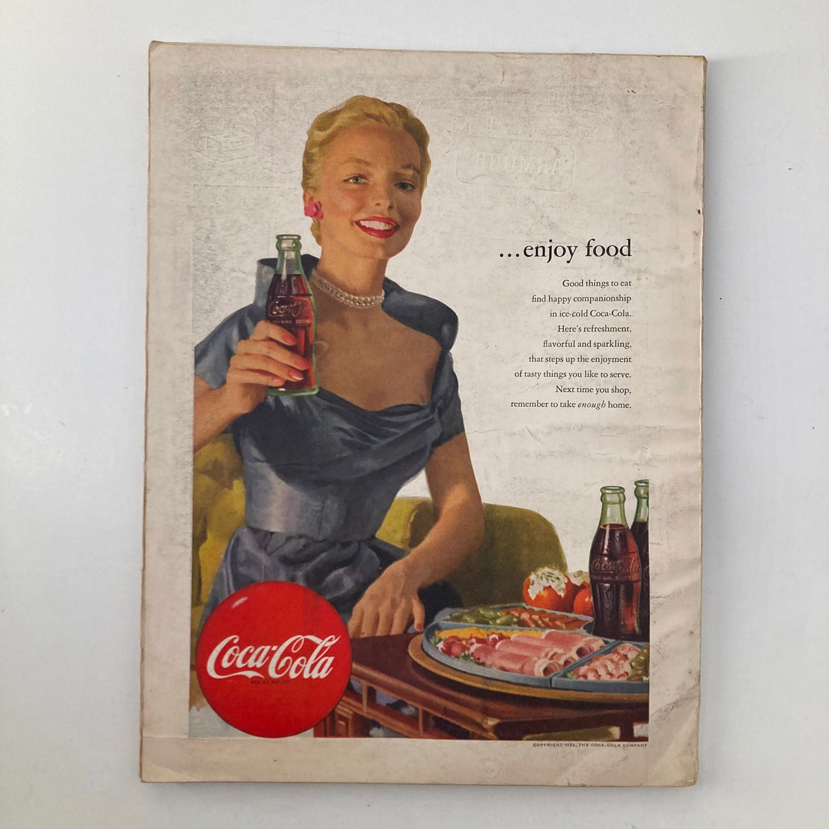 Back cover of the July 1952 Good Housekeeping Magazine featuring a vintage Coca-Cola advertisement with a smiling woman holding a bottle of Coke.