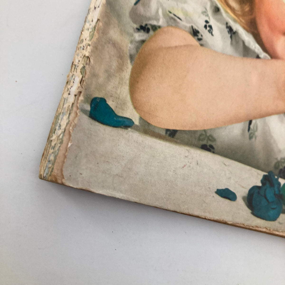 Close-up of the edge of the cover of VTG Good Housekeeping Magazine October 1956, highlighting its aged and vintage characteristics with colorful clay remnants.