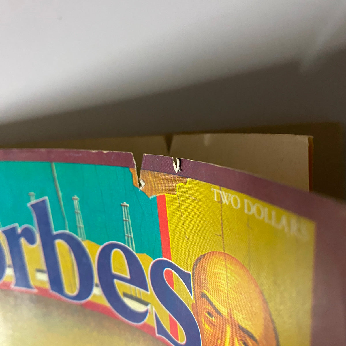 Close-up view of the damaged top section of the April 28, 1980 Forbes Magazine, showing wear and tear on the cover.
