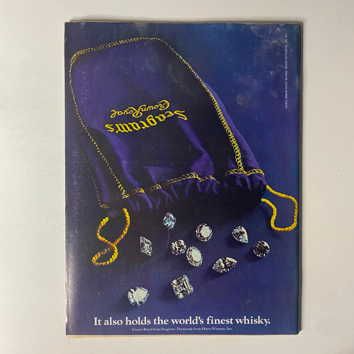 Back cover of Forbes Magazine from February 15, 1977, featuring an advertisement for Seagram's Crown Royal, emphasizing luxury and quality.