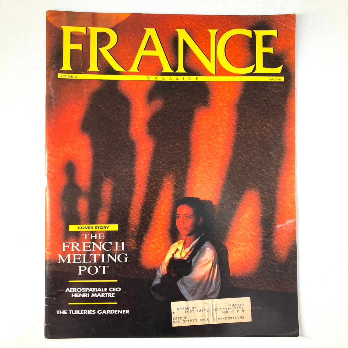 Cover of France Magazine Fall 1991 No. 20 featuring the cover story 'The French Melting Pot' and 'The Tuileries Gardener'. The magazine showcases a woman against a vibrant orange background, illustrating themes of multiculturalism and gardening in France.