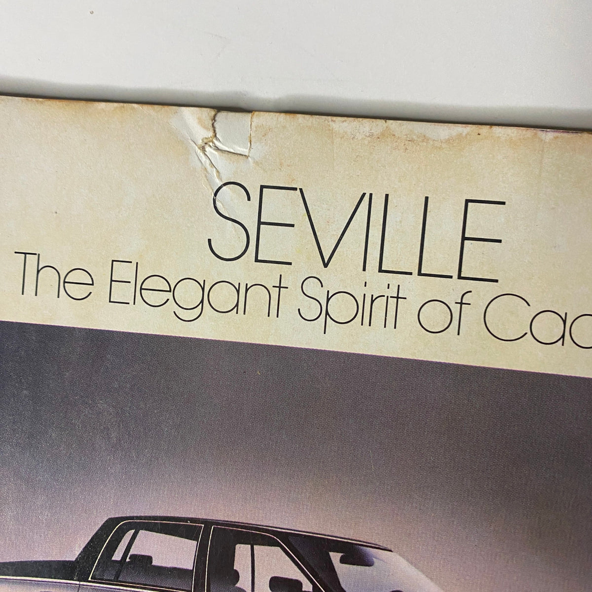 Close-up of the back cover of Forbes Magazine April 20, 1987, highlighting the Cadillac Seville tagline 'The Elegant Spirit of Cadillac'.