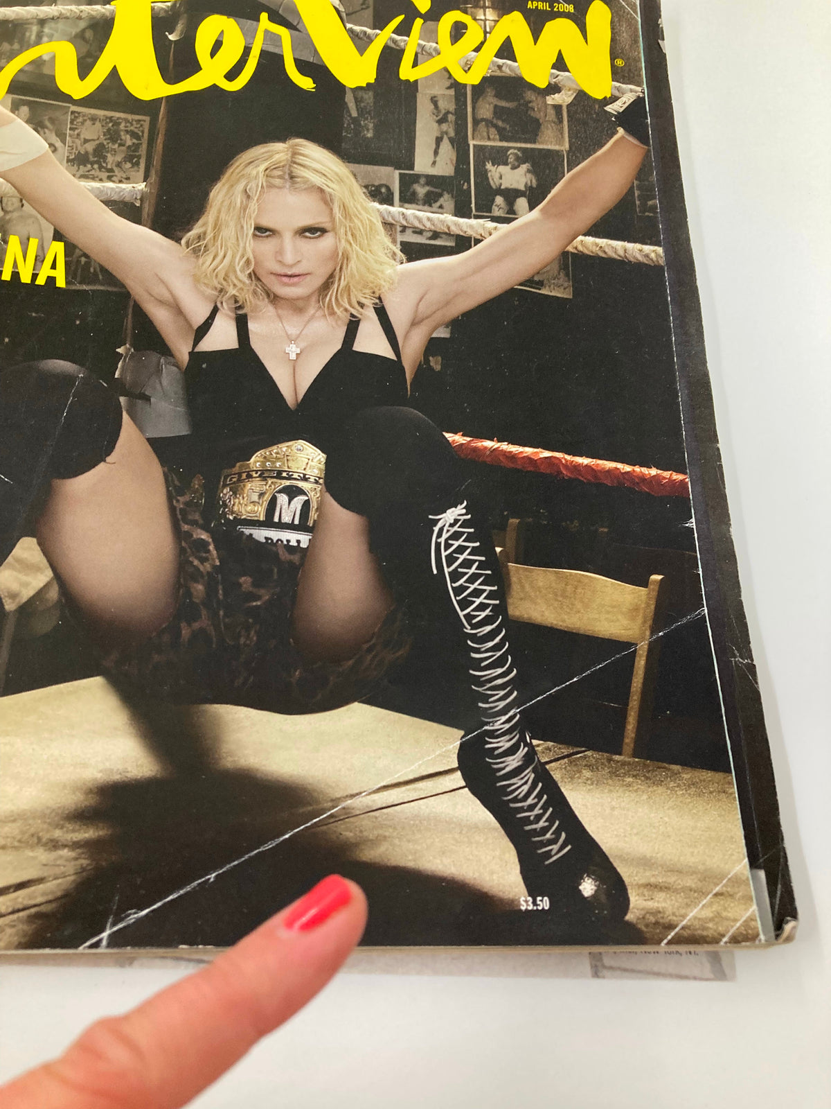 Cover image of Interview Magazine April 2008 featuring Madonna, dressed in a striking outfit and holding a championship belt, highlighting the theme 'Madonna On Why We Must Be Free No Label'. The image showcases Madonna's bold fashion statement against a wrestling ring backdrop.