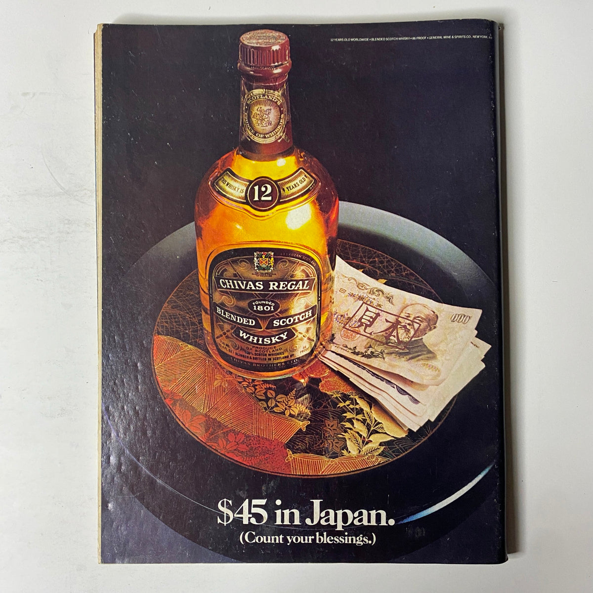 Cover of Forbes Magazine September 24, 1984, featuring a bottle of Chivas Regal blended Scotch whisky on a decorative plate and cash, captioned '$45 in Japan. (Count your blessings.)'