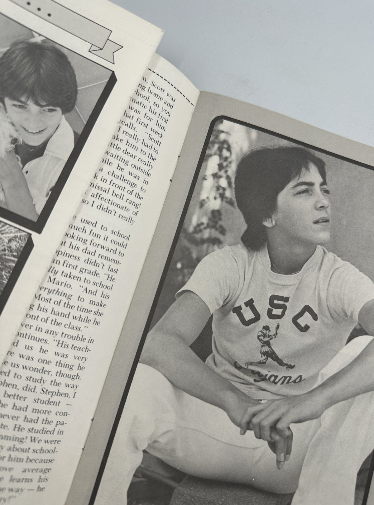 Close-up of a black and white photo of Scott Baio wearing a USC t-shirt, engaged in reflection. Featured in 'The Secret of Scott Baio' magazine, this image showcases his appeal during his rise to fame.