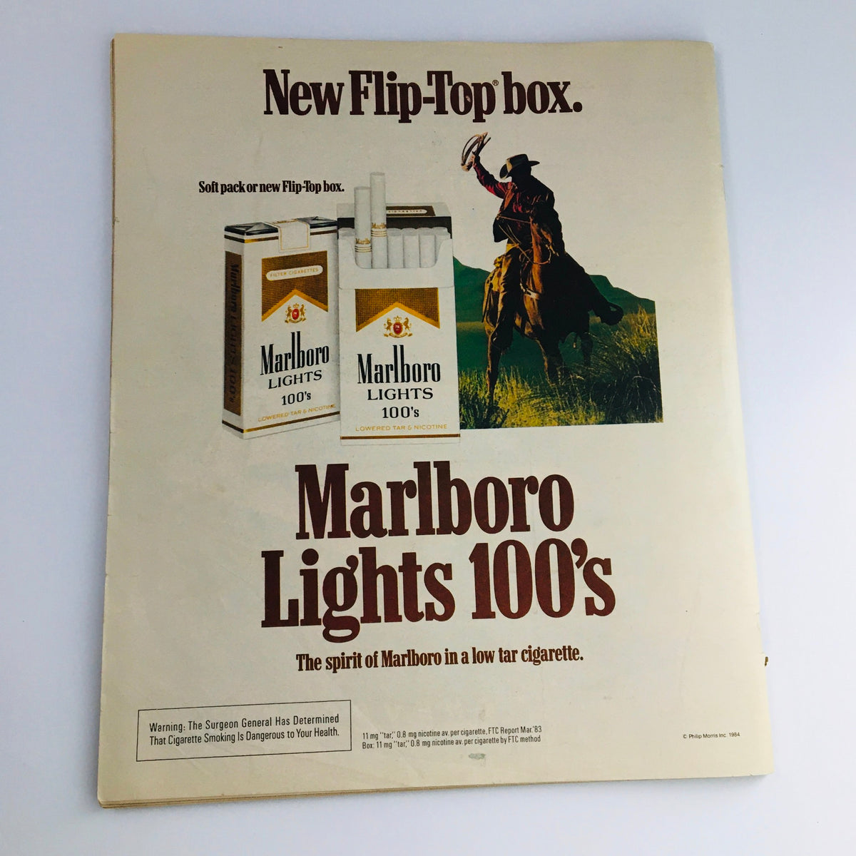 Ad page from Rolling Stone Magazine February 16, 1984, showcasing Marlboro Lights 100's cigarette advertisement with a cowboy illustration.