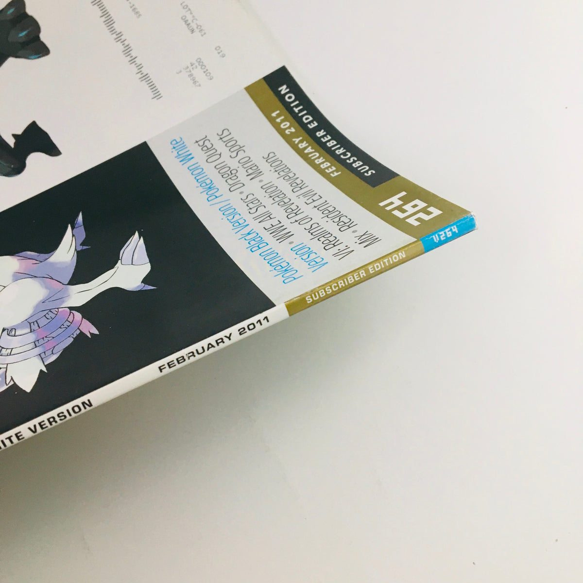 Close-up view of the spine of Nintendo Power Magazine from February 2011, highlighting its status as a subscriber edition with features on Pokémon Black Version & White Version.