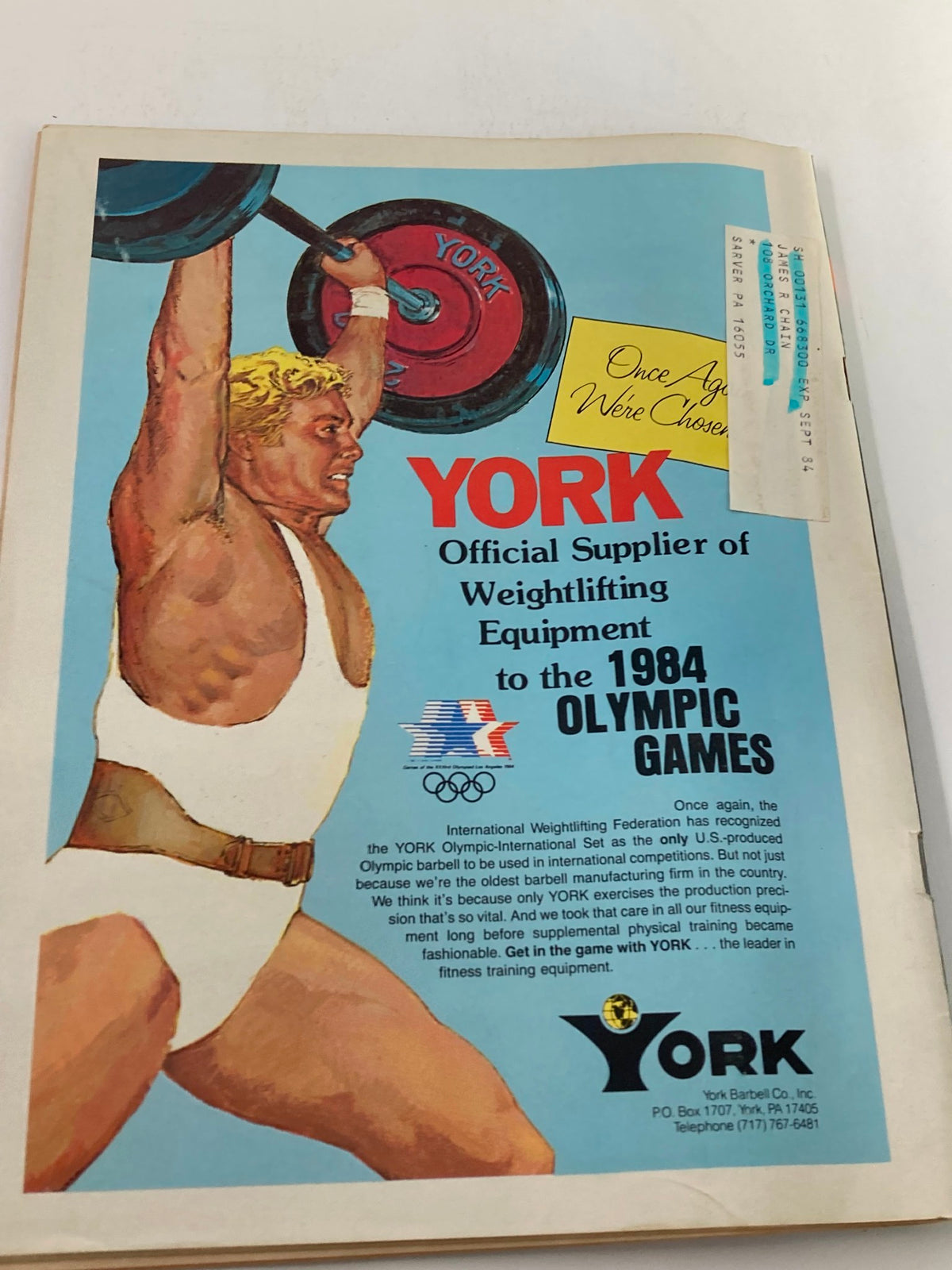 Advertisement for York Barbell, showing an athlete lifting weights, from the VTG Strength & Health Magazine March 1984 Vol 52 #2. Promotes York as the official supplier of weightlifting equipment to the 1984 Olympic Games.