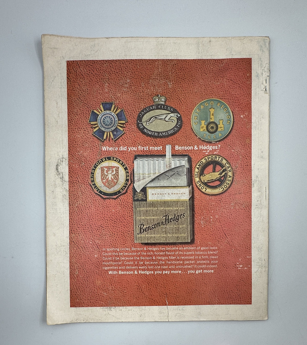 Back cover of Holiday Magazine July 1963 displaying vintage advertising for Benson & Hedges, featuring various badges and logos.