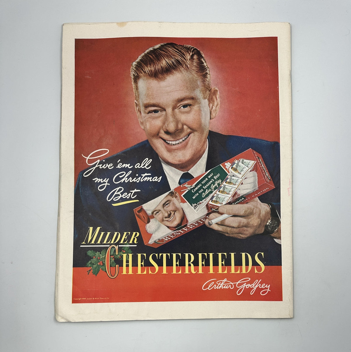 Advertisement page in Collier’s Magazine December 10, 1949, showcasing a Christmas greeting for Chesterfield cigarettes with a smiling salesman holding a gift.