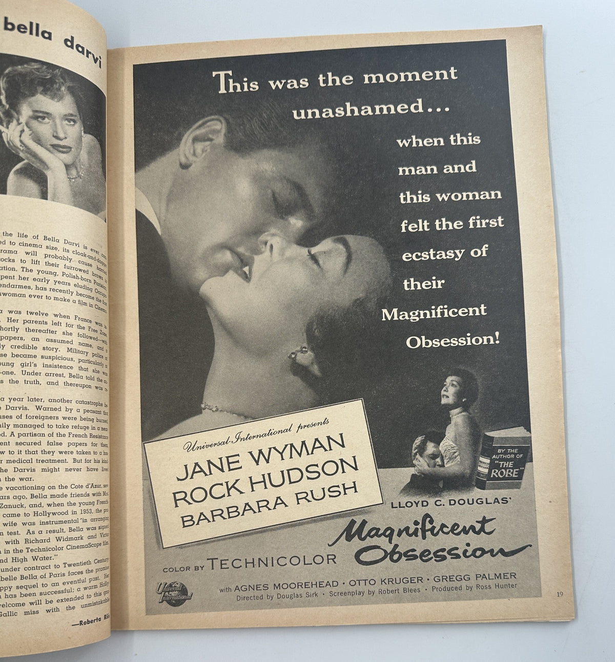 A magazine advertisement from Screen Stories Magazine August 1954 featuring Jane Wyman and Rock Hudson in Magnificent Obsession, highlighting a romantic moment. The ad promotes the film's captivating themes.