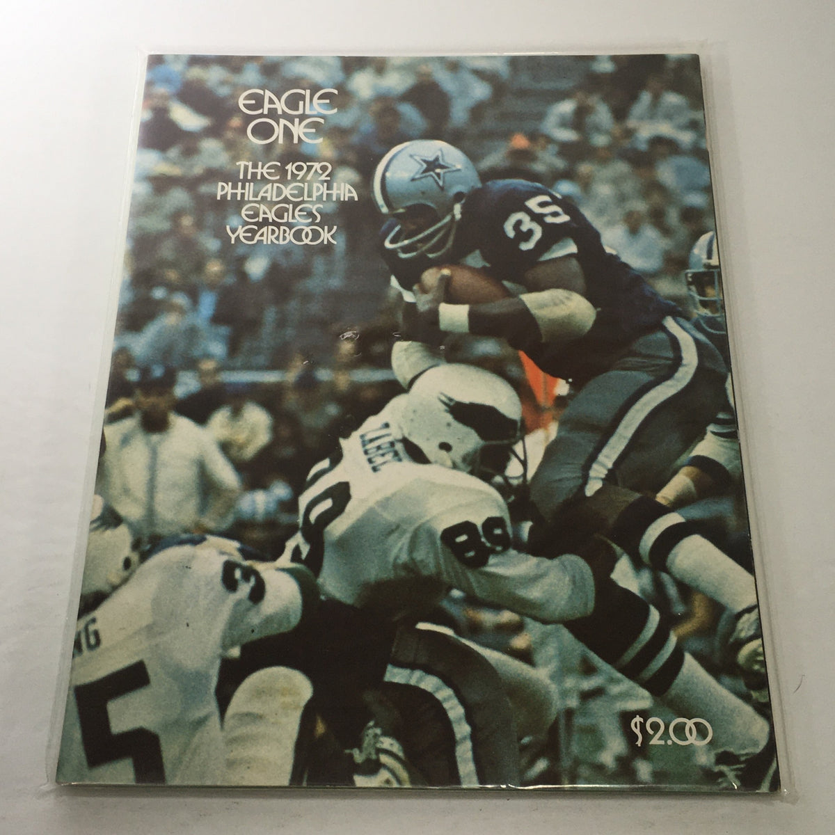 Cover of Eagle One: The 1972 Philadelphia Eagles Yearbook featuring football action with players in white and blue jerseys. The yearbook captures the nostalgia of early 1970s football, ideal for collectors and Philadelphia Eagles fans.