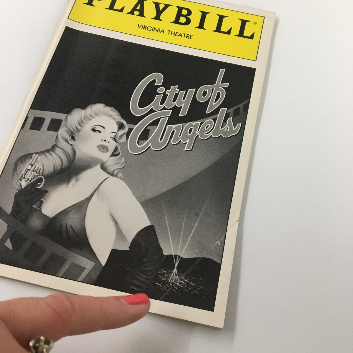 Close-up of the 1990 Playbill for City of Angels at Virginia Theatre, displaying the cover art and logo with a hand pointing to it.