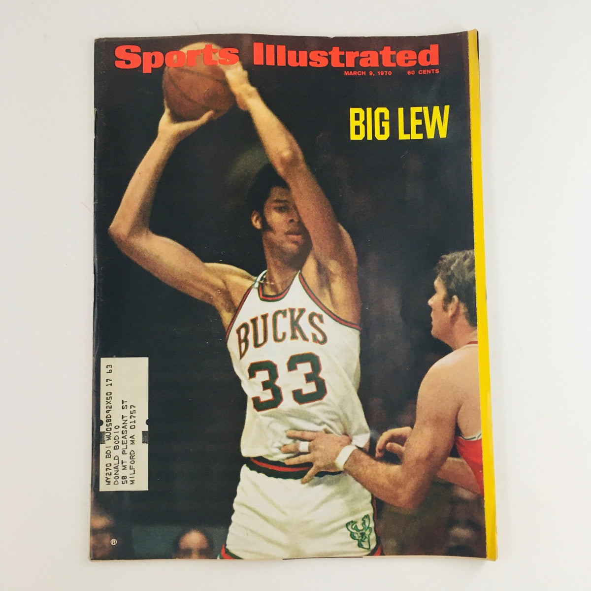 Cover of Sports Illustrated Magazine March 9, 1970 featuring Kareem Abdul-Jabbar, then known as Big Lew, in a Milwaukee Bucks jersey during a basketball game. This vintage magazine captures the essence of early 1970s basketball and is ideal for sports collectors.