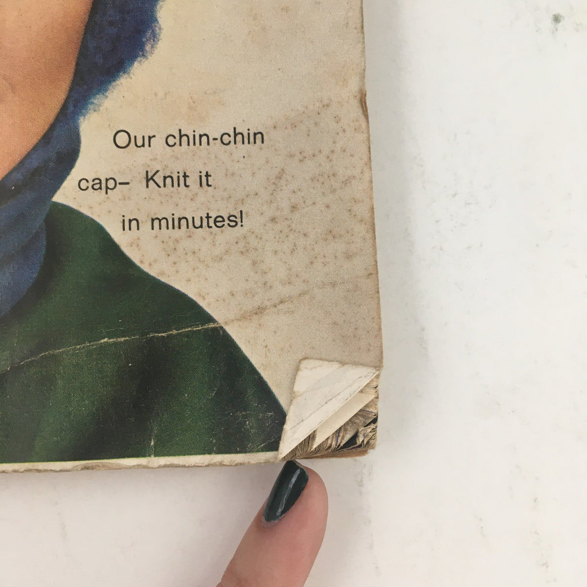 Bottom corner detail of Good Housekeeping Magazine January 1966 showing the damaged edge of the cover and text about a knit cap.