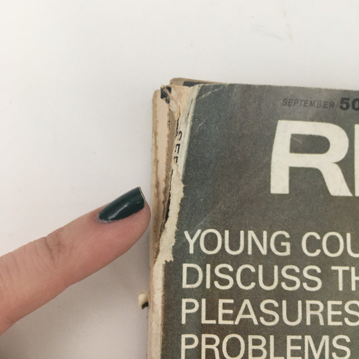 Detailed view of the edge of Redbook Magazine September 1970, highlighting worn pages and text about young couples discussing marital pleasures.